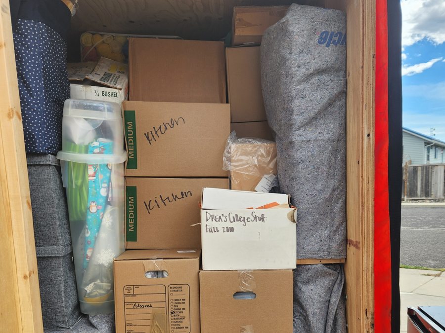 A moving truck filled with boxes and items, featuring the logo of All Smile Moving on the side.
